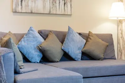a bunch of pillows on a blue couch at Granary Suite No3 - Donnini Apartments in Ayr