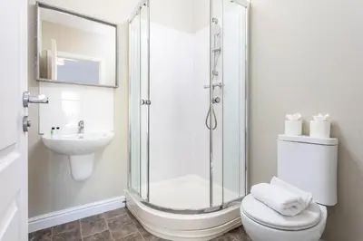 a bathroom with a shower and a toilet and a sink at Granary Suite No3 - Donnini Apartments in Ayr