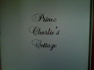 a sign that reads pine chutes violence written in black handwriting at Prince Charlie's Cottage in Gretna Green