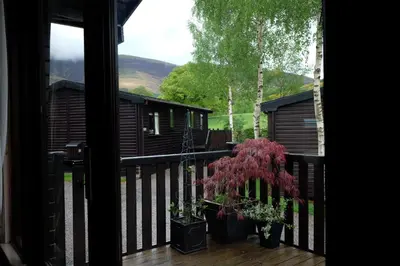 a view of a house from a balcony with a tree at Fellside Lodge in Keswick