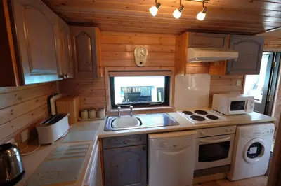 a small kitchen with a sink and a stove at Fellside Lodge in Keswick
