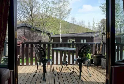 a patio with a table and chairs on a deck at Fellside Lodge in Keswick