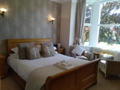 a bedroom with a bed and a chair and a window at Link House in Bassenthwaite Lake