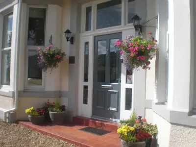 a front door of a house with potted flowers at Link House in Bassenthwaite Lake