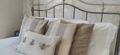 a group of pillows on a bed with a headboard at Link House in Bassenthwaite Lake