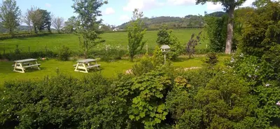 two picnic tables in a garden with a field at Link House in Bassenthwaite Lake