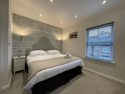 a bedroom with a large bed and a brick wall at Isabel Cottage in Keswick