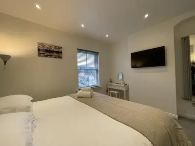 a bedroom with a large bed and a flat screen tv at Isabel Cottage in Keswick