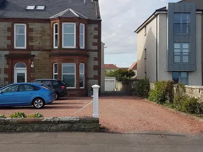 a blue car parked in front of a house at Fairways Cottages in Prestwick