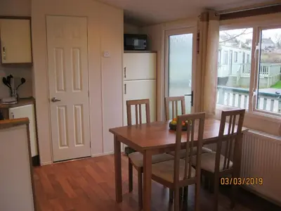 a kitchen with a table and chairs and a window at 27 The Beeches, Gilcrux, Nr Cockermouth, Cumbria in Gilcrux