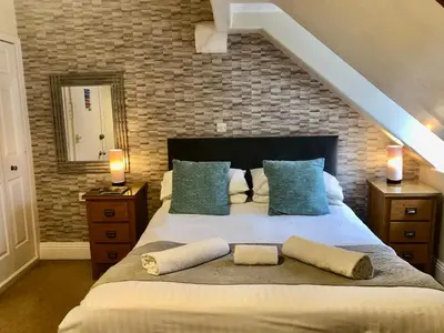 a bedroom with a large bed with pillows on it at Ravensworth House in Keswick