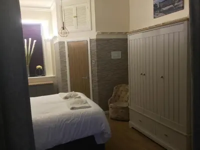 a small bedroom with a bed and a chair at Ravensworth House in Keswick