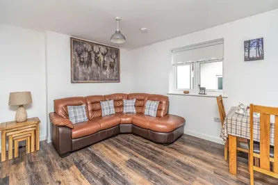 a living room with a brown leather couch at Sam's Cottage in Keswick