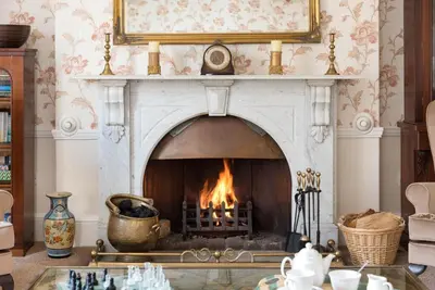 a fireplace in a living room with a fire at Acorn House in Keswick