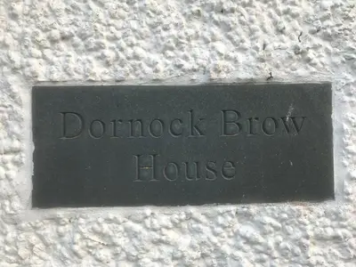a sign that says doncaster brow house on the ground at The Waterside Rooms in Annan