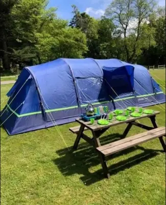 a picnic table in front of a tent at Glen Wyllin Campsite in Kirkmichael