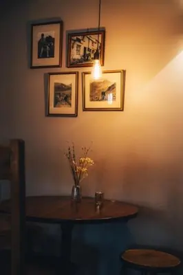 a table with a vase of flowers and pictures on the wall at Three Shires Inn in Little Langdale