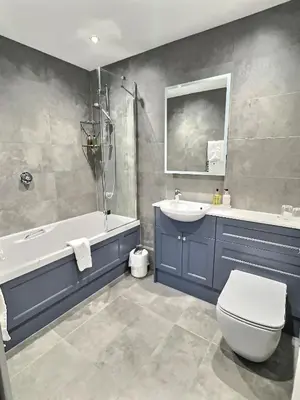 a bathroom with a tub and a toilet and a sink at Three Shires Inn in Little Langdale