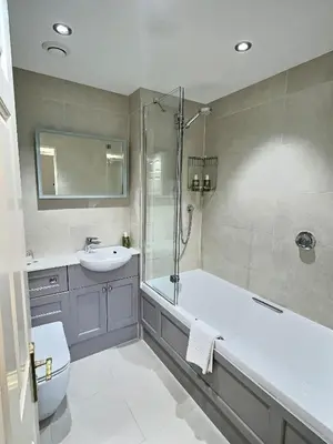a bathroom with a tub and a sink and a shower at Three Shires Inn in Little Langdale