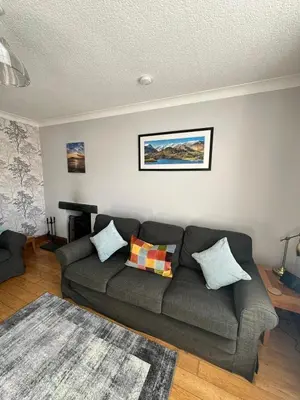 a living room with a gray couch in a room at Stanger Cottage in Keswick