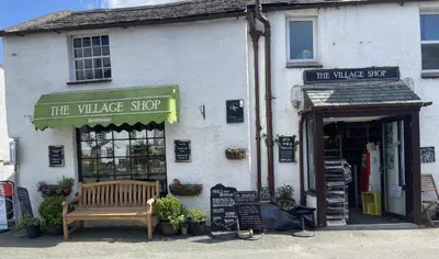 a shop with a bench in front of it at Stanger Cottage in Keswick