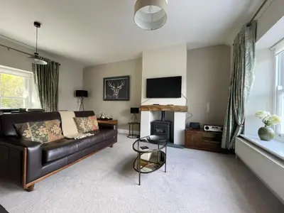 a living room with a leather couch and a television at Lords Seat in Keswick