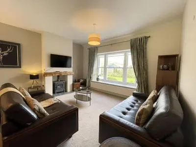a living room with two leather couches and a television at Lords Seat in Keswick