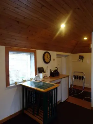 a kitchen with a counter and a clock on the wall at Groom's Cottage in Moffat