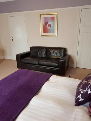 a black leather couch in a living room with a couch at Hamilton House in Dumfries