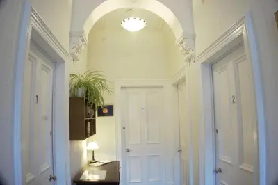 a hallway with an archway and a white door at Barns Serviced Accommodation in Ayr