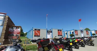 a row of motorcycles parked in a parking lot at IOMTT Village at Isle of Man TT in Douglas