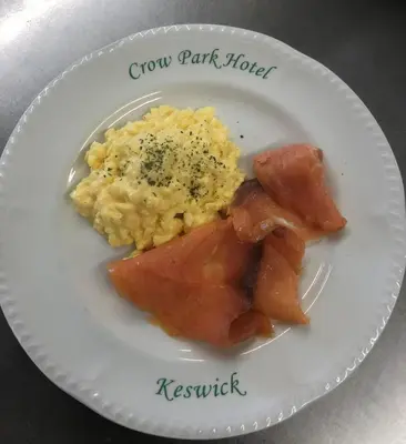 a plate of food with eggs ham and bacon at Crow Park Hotel in Keswick