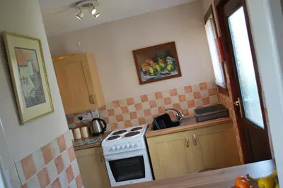 a small kitchen with a stove and a sink at 11 Laigh Isle in Isle of Whithorn