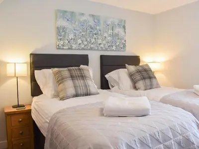 two beds in a bedroom with a painting on the wall at Hovera in Glenridding