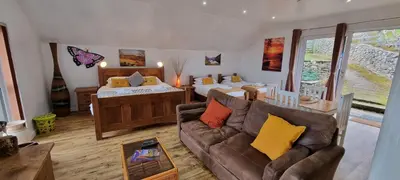 a living room with a couch and a bedroom at Windsor Cottage on The Big 
