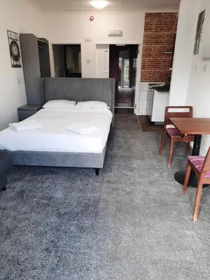 a bedroom with a bed and a desk and a table at The Townhouse Self Catering in Dumfries