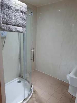 a bathroom with a shower and a toilet and a sink at The Townhouse Self Catering in Dumfries