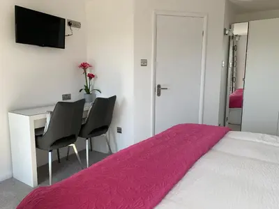a bedroom with a bed and a desk with two chairs at The Bungalows Guesthouse in Threlkeld