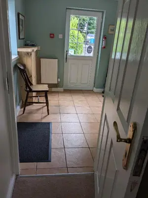 a room with a door and a chair and aoyer with a door at Boreland Farm in Dunscore
