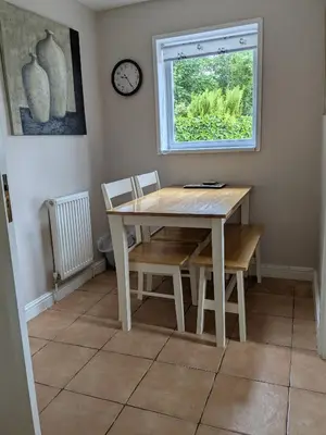 a table and chairs in a room with a window at Boreland Farm in Dunscore