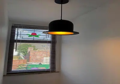a black light hanging in a room with a window at Fisher Holiday Cottage Ayrshire in Girvan