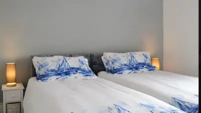 a bedroom with two beds with blue and white pillows at Dove cottage in Allonby