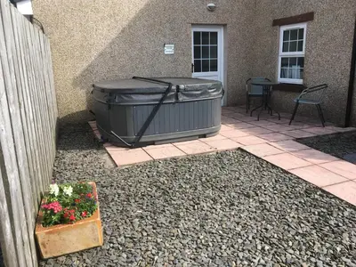 a large tub sitting outside of a house at OLD BAKEHOUSE in Holmrook