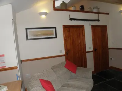 a living room with a couch and red pillows at OLD BAKEHOUSE in Holmrook