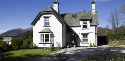 a large white house with a black roof at Claremont House Keswick in Keswick