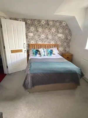 a bedroom with a bed and a white door at Claremont House Keswick in Keswick