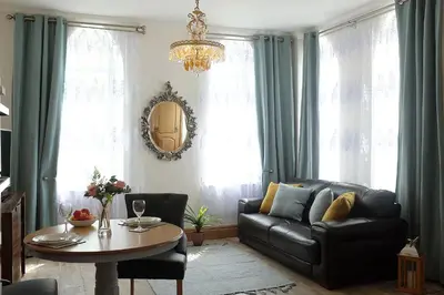 a living room with a black leather couch and a table at Welch House in Douglas
