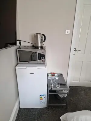 a small refrigerator with a microwave on top of it at Fairladies Barn Guest House in St Bees