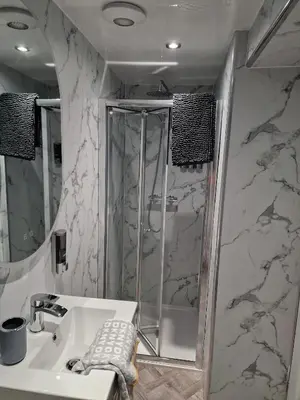 a bathroom with a shower and a sink at Fairladies Barn Guest House in St Bees