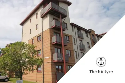 a building with a balcony on the side of it at Kintyre Apartment in Ayr